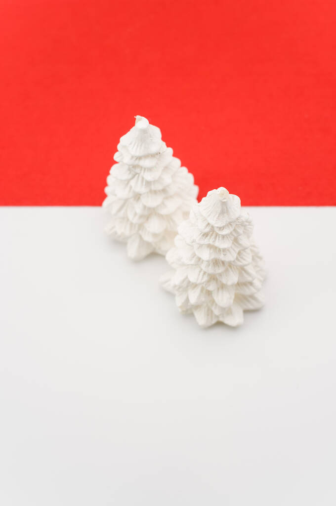 Рождественский декоративный фон с елками на красно-белой поверхности с копировальным пространством - Фото, изображение