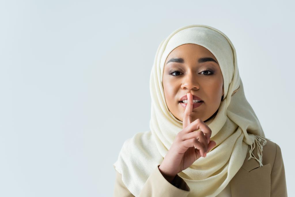młoda muzułmanka w hidżabie pokazuje cichy znak izolowany na szarości - Zdjęcie, obraz