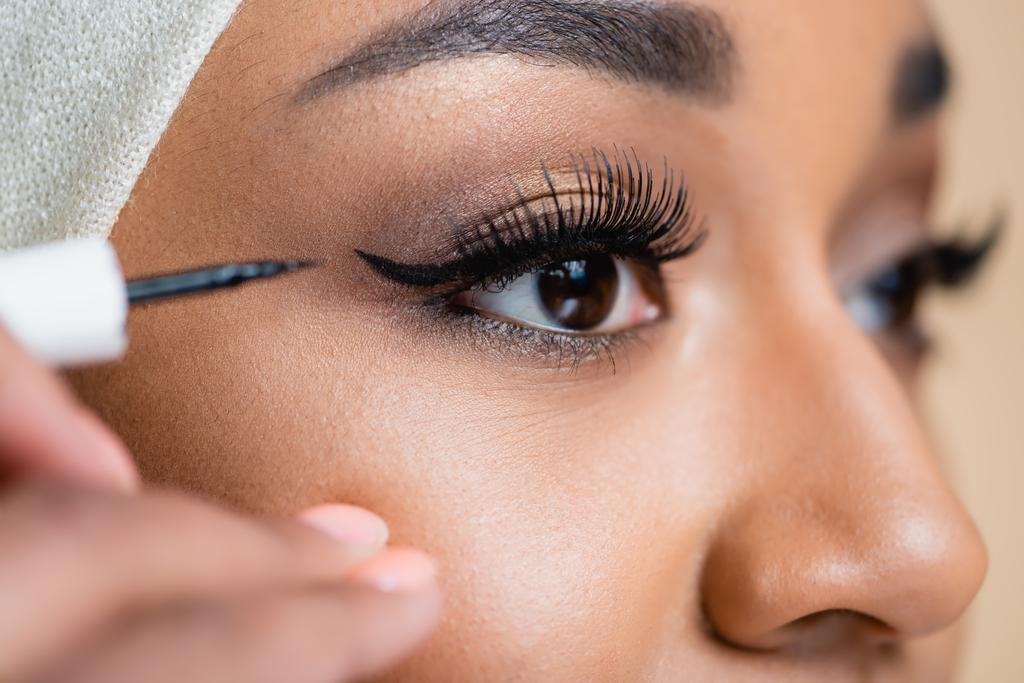 close-up de jovem mulher árabe aplicando forro olho preto - Foto, Imagem
