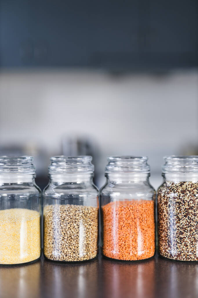 прозорі комори з різними видами зерна і бобових культур, включаючи сочевицю з кіоки гречки і ячменю на бентопі з кухонним боке, концепція простих інгредієнтів
 - Фото, зображення