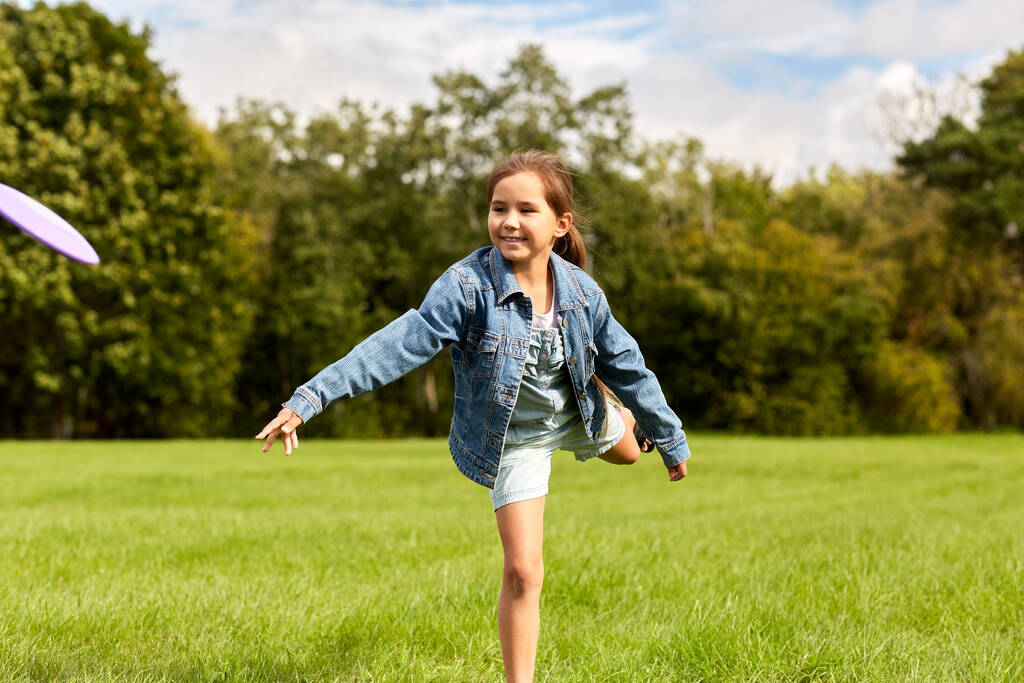gelukkig meisje spelen met vliegende disc in park - Foto, afbeelding