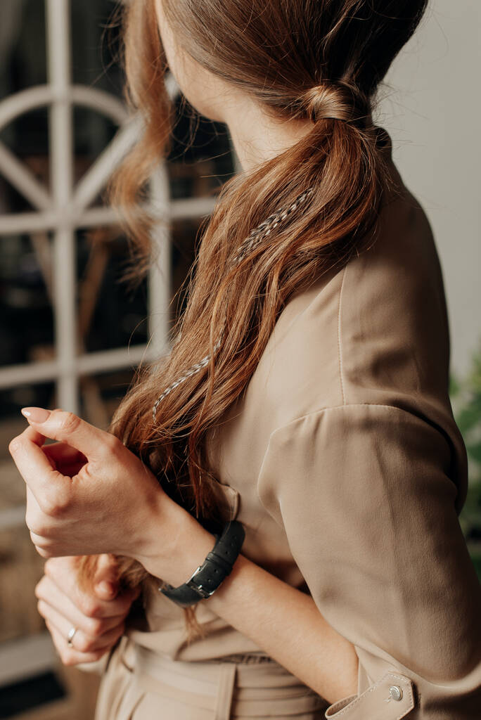 стильная стройная девушка в платье и часы с длинными волосами стоит боком - Фото, изображение