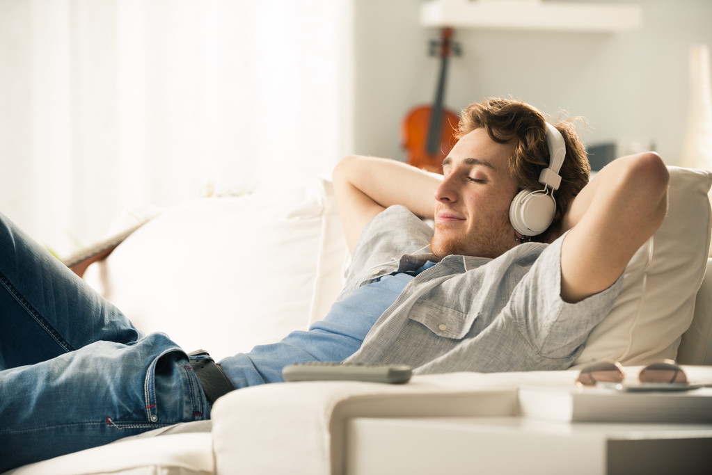 Guy with headphones on sofa - Photo, Image