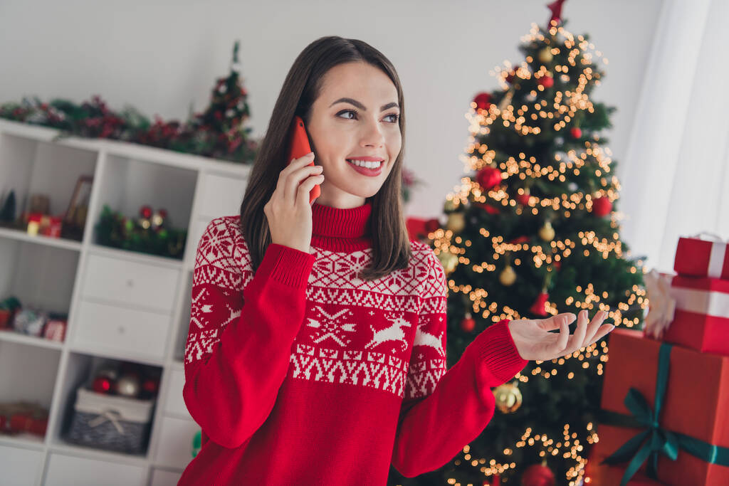 Foto de niña encantadora hablan escuchar teléfono inteligente en línea árbol de hoja perenne decoración diciembre en interiores - Foto, imagen