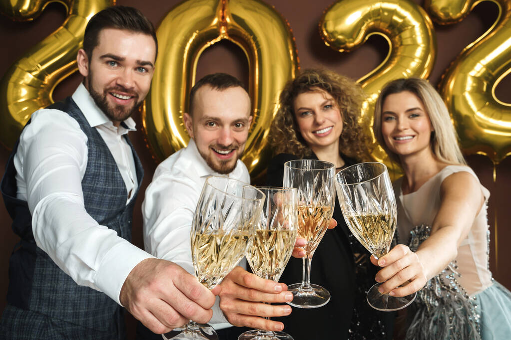 Gruppe schön gekleideter Partygänger feiert Neujahr 2022 und trinkt Sekt - Foto, Bild