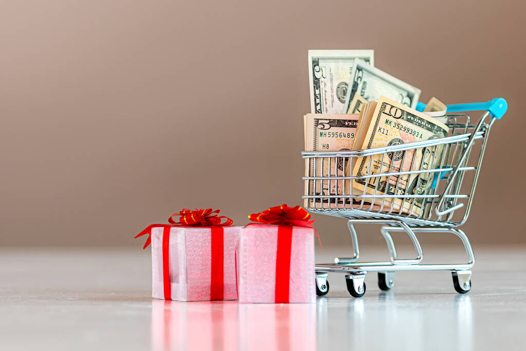 Karácsonyi kiadástervezés koncepció, ajándékdobozok és bevásárlókosár tele pénzzel - Fotó, kép