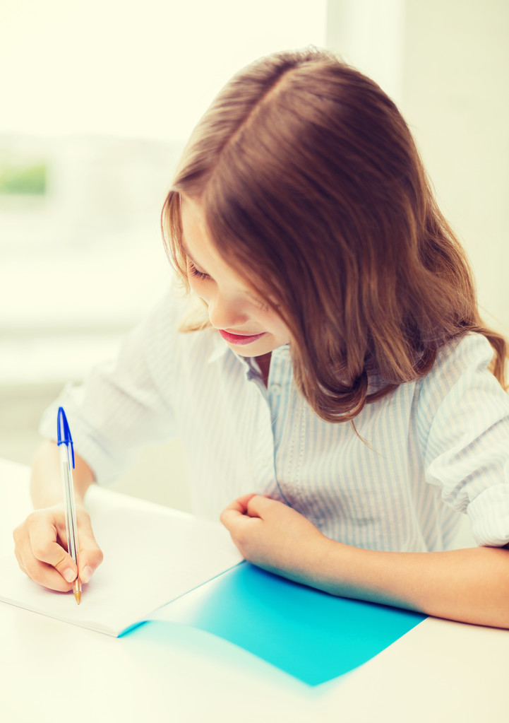Schülerin schreibt in der Schule in Notizbuch - Foto, Bild