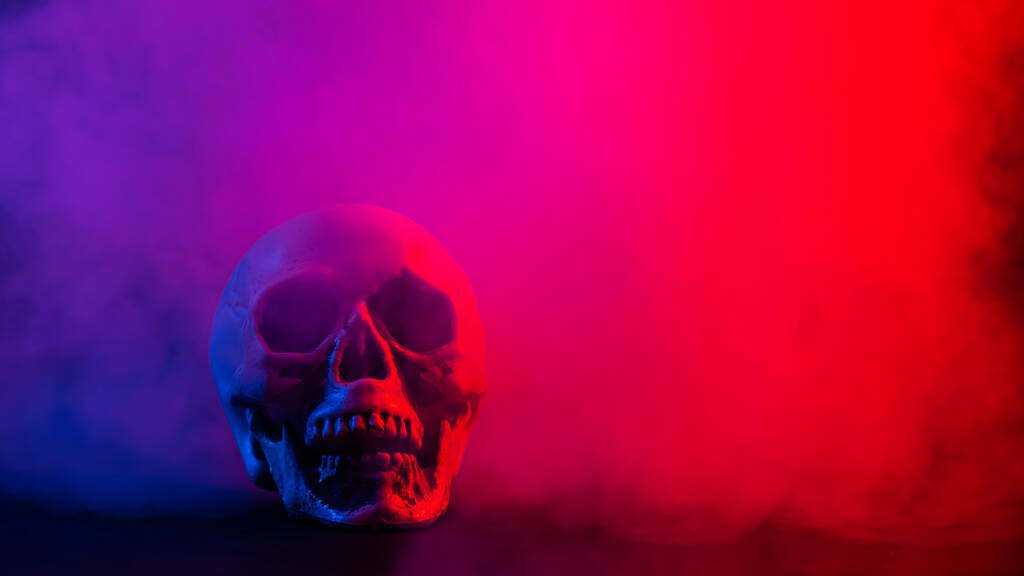 Crâne humain en fumée rose et bleue sur fond noir. Halloween. - Photo, image