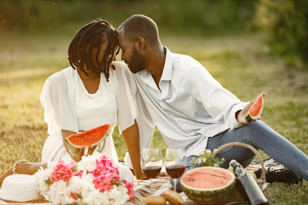 Couple afro-américain avec pastèque sur une prairie - Photo, image
