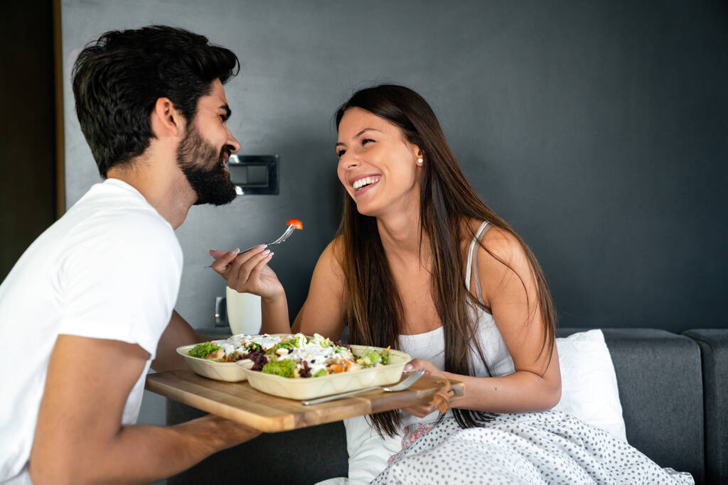 Un homme apporte le petit déjeuner à sa femme au lit. Poeple, couple, amour, concept culinaire - Photo, image