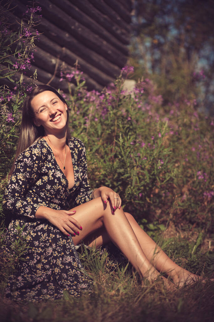 Chica joven en vestido de verano sentado en la hierba, sonriendo - Foto, Imagen