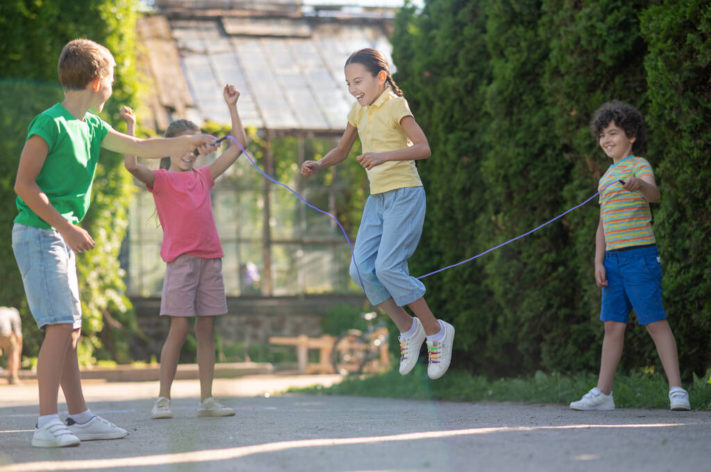 Dívka s copánky skákací lano s přáteli - Fotografie, Obrázek