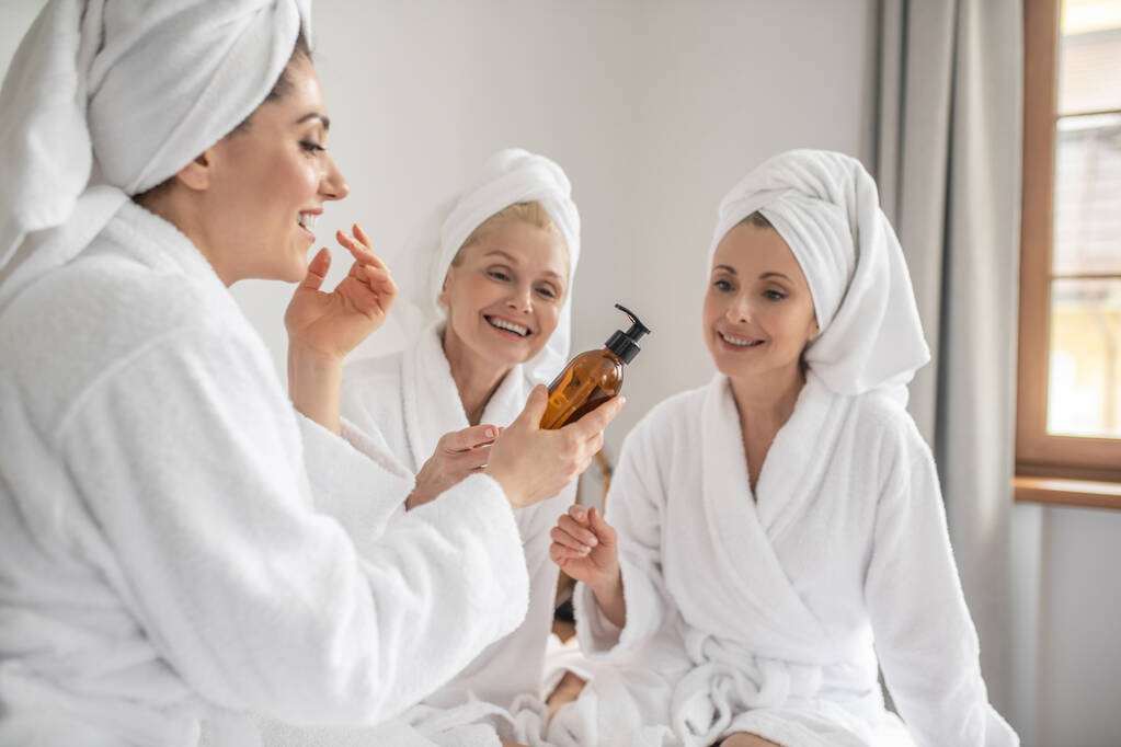 Frauen in Bademänteln probieren neue Kosmetik aus - Foto, Bild