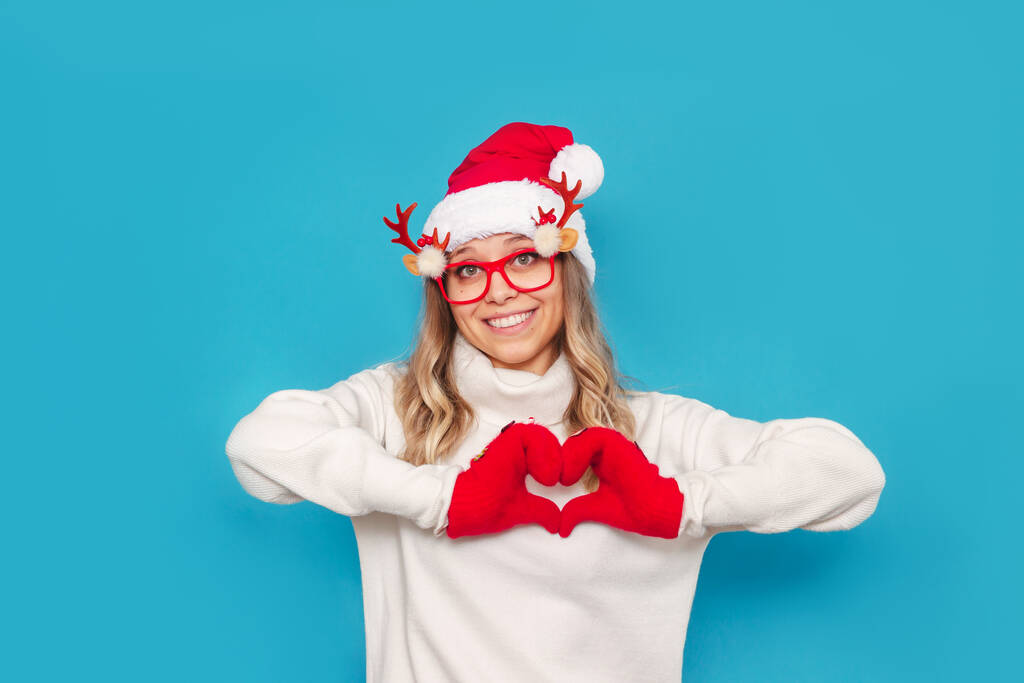 bella giovane donna in cappello di Babbo Natale e occhiali che mostrano il segno del cuore - Foto, immagini