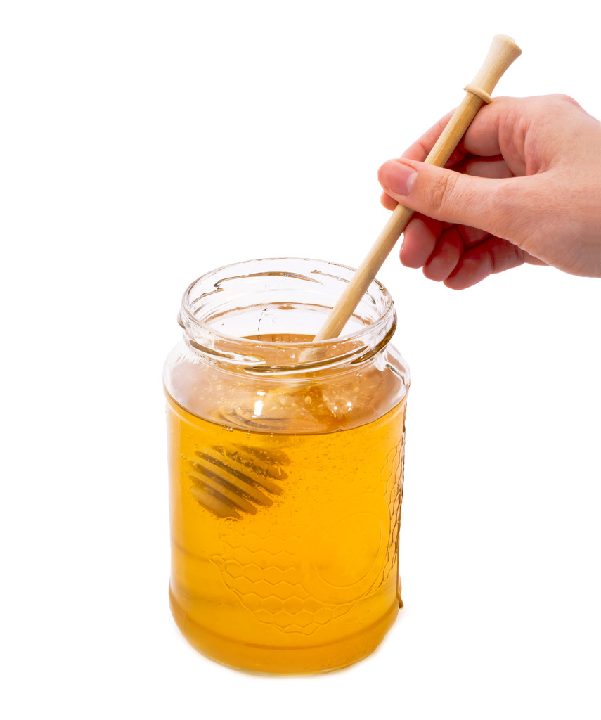 Botella de miel y manos femeninas
. - Foto, imagen