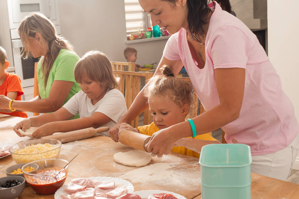 gli educatori insieme ai bambini in età prescolare fanno la pizza - Foto, immagini