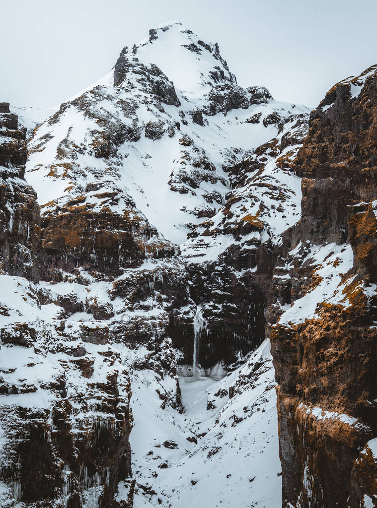 Um desfiladeiro secreto chamado "Canyon Mul=jufur" na Islândia do Sul. Cachoeira abaixo do topo da montanha no inverno e paisagem de neve. Destino turístico superior. Sudeste da Islândia, Europa - Foto, Imagem