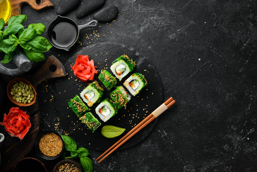 Sushi-Rollen mit Kaviar, Chuka-Salat und Käse. Traditionelle japanische Küche. Ansicht von oben. - Foto, Bild