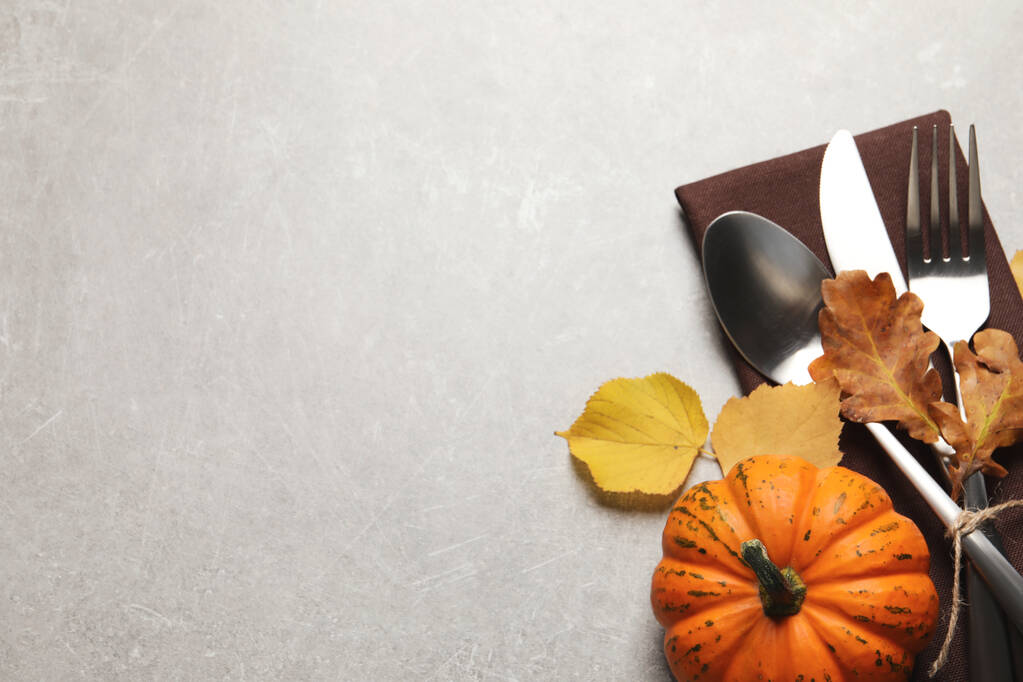 Bestek, herfstbladeren en pompoen op lichtgrijze tafel, plat gelegd. Ruimte voor tekst - Foto, afbeelding