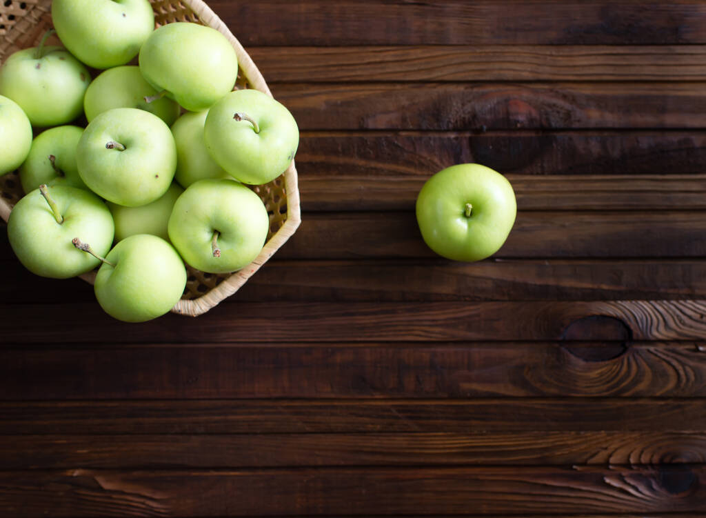 Muitas maçãs verdes maduras em um fundo de madeira. - Foto, Imagem