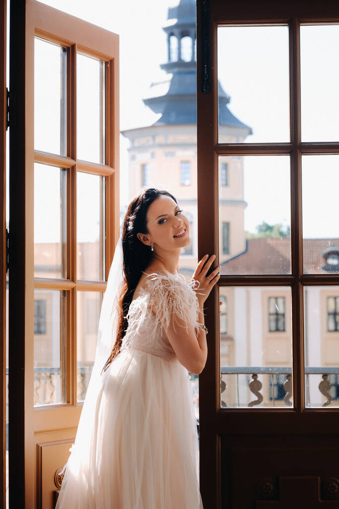 Elegantní nevěsta na balkóně starobylého hradu ve městě Nesvizh. - Fotografie, Obrázek