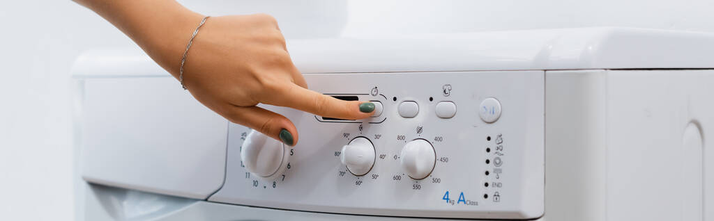 visão parcial da mulher pressionando o botão na máquina de lavar roupa, banner  - Foto, Imagem