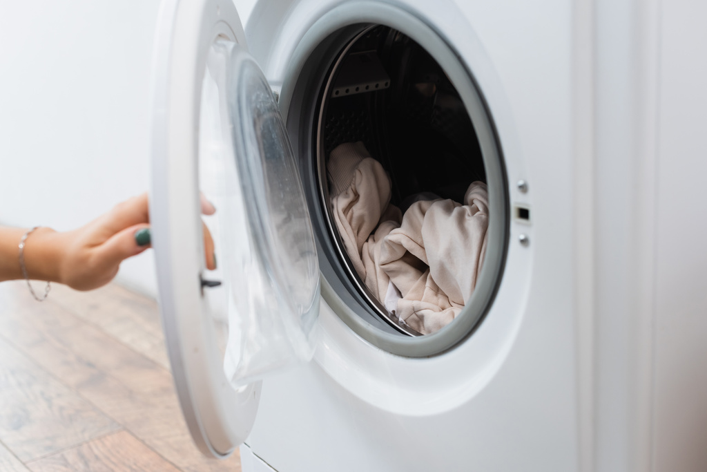 vista cortada da mulher abrir máquina de lavar roupa com lavanderia - Foto, Imagem