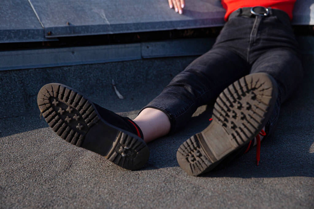 Жінка ноги в джинсах і черевиках на даху
 - Фото, зображення