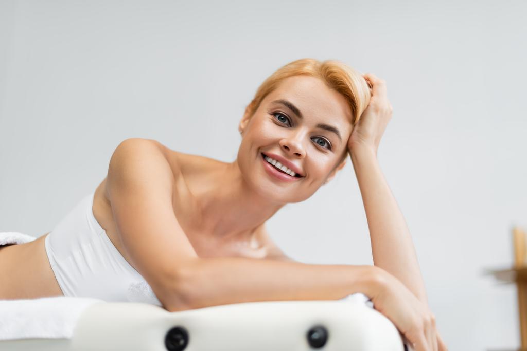 veselá blondýnka klient ležící na masážním stole  - Fotografie, Obrázek