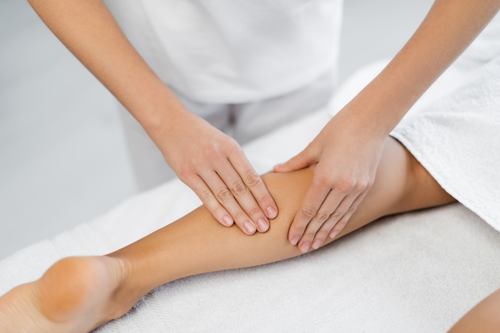 vista ritagliata di massaggiatore professionista che fa massaggio ai piedi al cliente nel centro benessere  - Foto, immagini