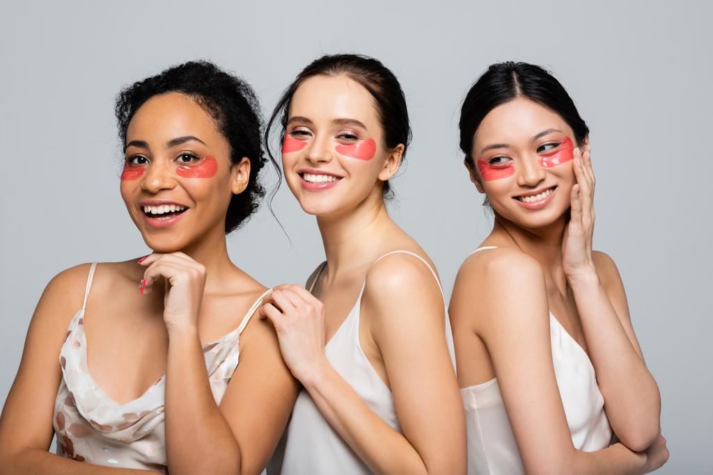 Mulheres multiculturais felizes com manchas oculares isoladas em cinza  - Foto, Imagem