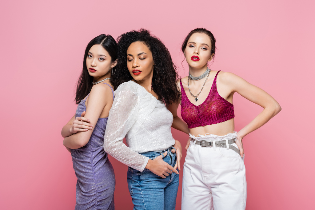 Young multiethnic women posing during party isolated on pink  - Photo, Image