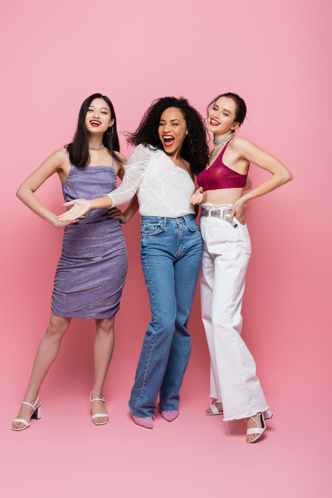 Donne multietniche alla moda che guardano la macchina fotografica su sfondo rosa - Foto, immagini