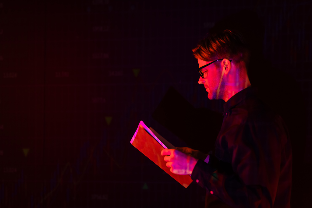 Вид сбоку программиста, держащего бумажную папку, изолированную черным цветом  - Фото, изображение