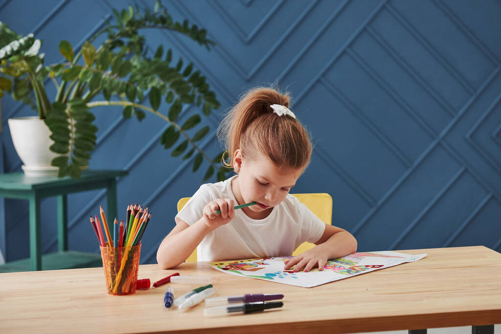 何を追加するかを考えます。Cute little girl in art school draws her first paintings by pencils and markers. - 写真・画像