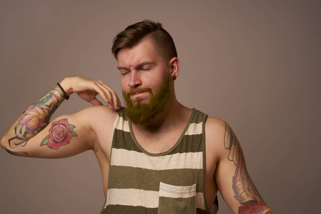 Όμορφος άντρας με τατουάζ στα χέρια του μοδάτα συναισθήματα χτένισμα - Φωτογραφία, εικόνα