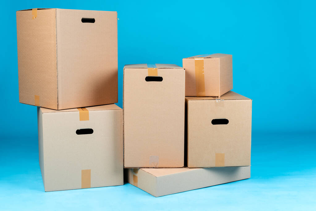 Empilement de boîtes en carton sur fond bleu - Photo, image
