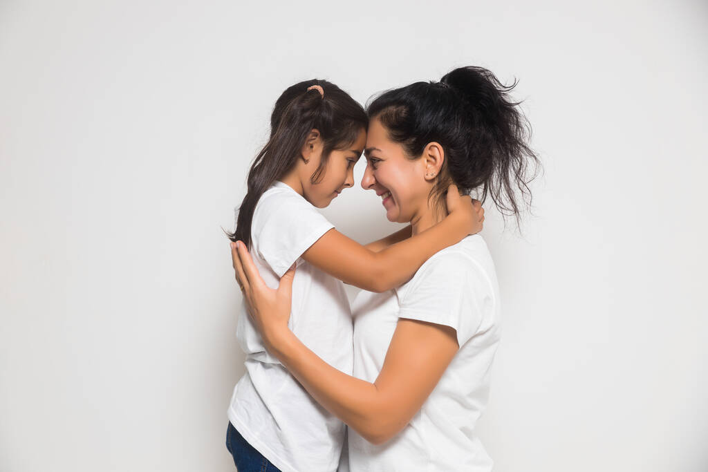 Cute little girl daughter hugging happy mother. Child embracing smiling mum. Family and Mothers Day concept - Photo, Image