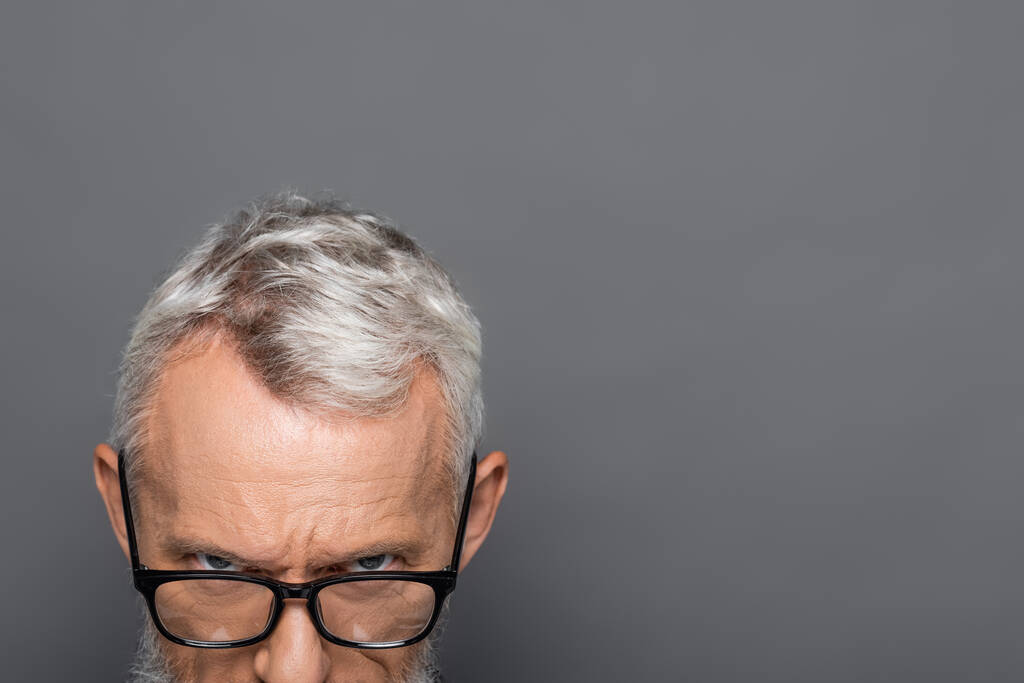 abgeschnittene Ansicht des bärtigen Geschäftsmannes mittleren Alters mit Brille isoliert auf grau - Foto, Bild