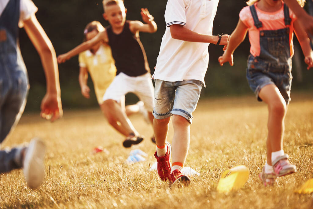 Door obstakels. Kinderen rennen in het veld op zonnige dag. Conceptie van een gezonde levensstijl. - Foto, afbeelding