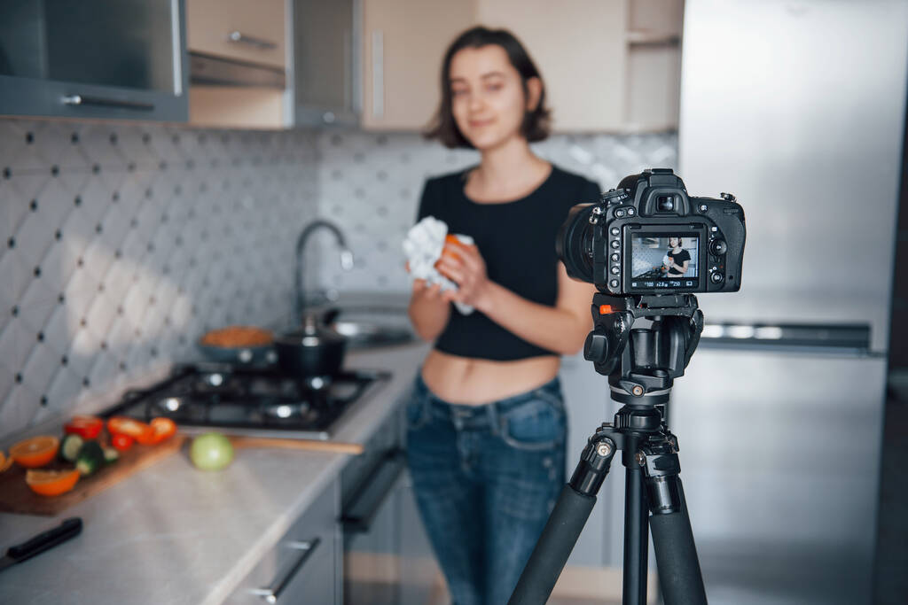 Oranje schoonmaken. Meisje in de moderne keuken thuis in haar weekend tijd in de ochtend. - Foto, afbeelding