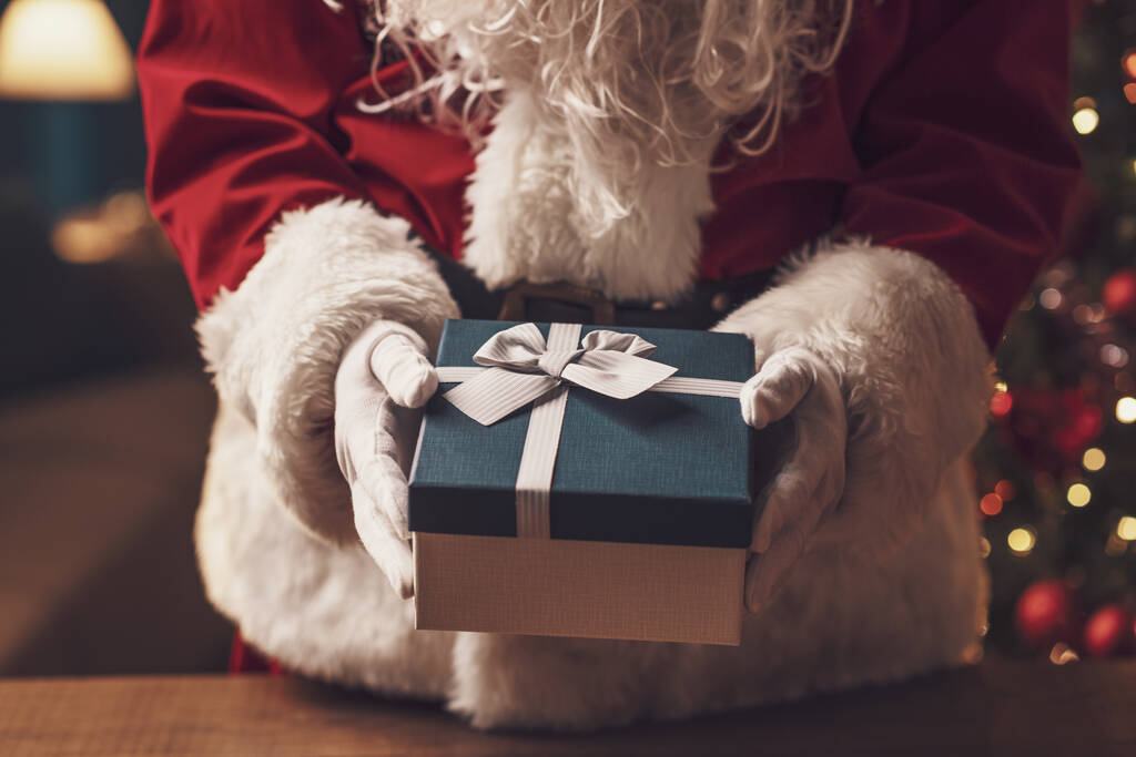 Santa Claus delivering Christmas gifts at home, holidays and celebrations concept - Photo, Image