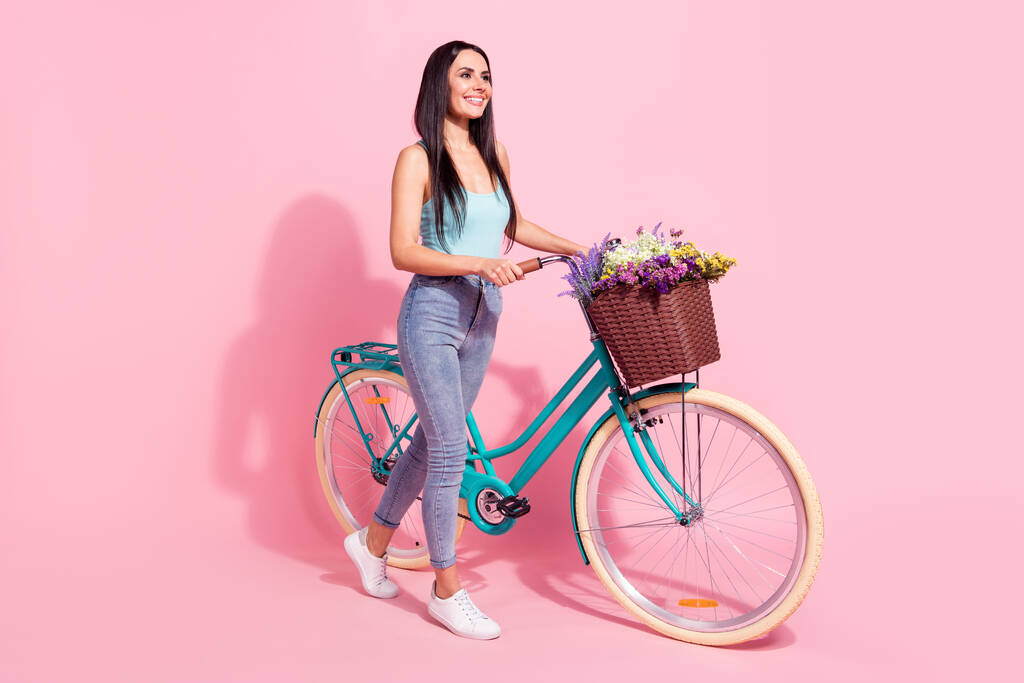 Ganzkörpergröße Ansicht der attraktiven fröhlichen Mädchen zu Fuß Fahrrad Freizeit isoliert über rosa Pastellfarbe Hintergrund - Foto, Bild