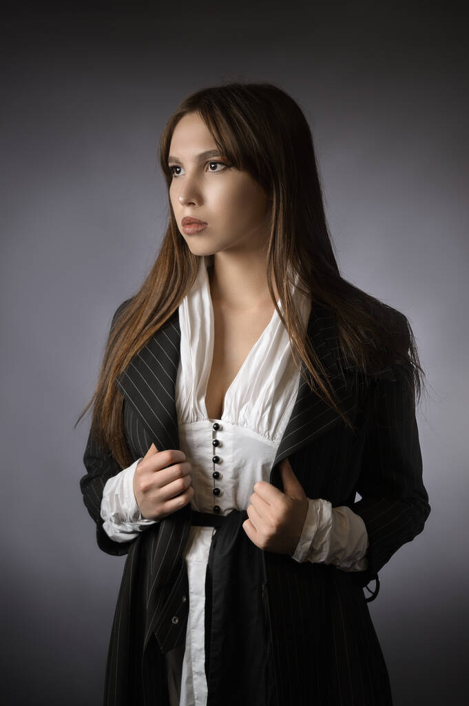 hermoso retrato de una chica en una chaqueta. estilo oficina. Fondo gris - Foto, imagen