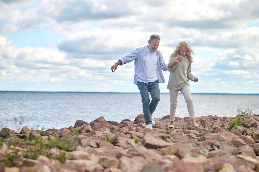 Mies ja nainen kävelemässä käsin lähellä merta - Valokuva, kuva