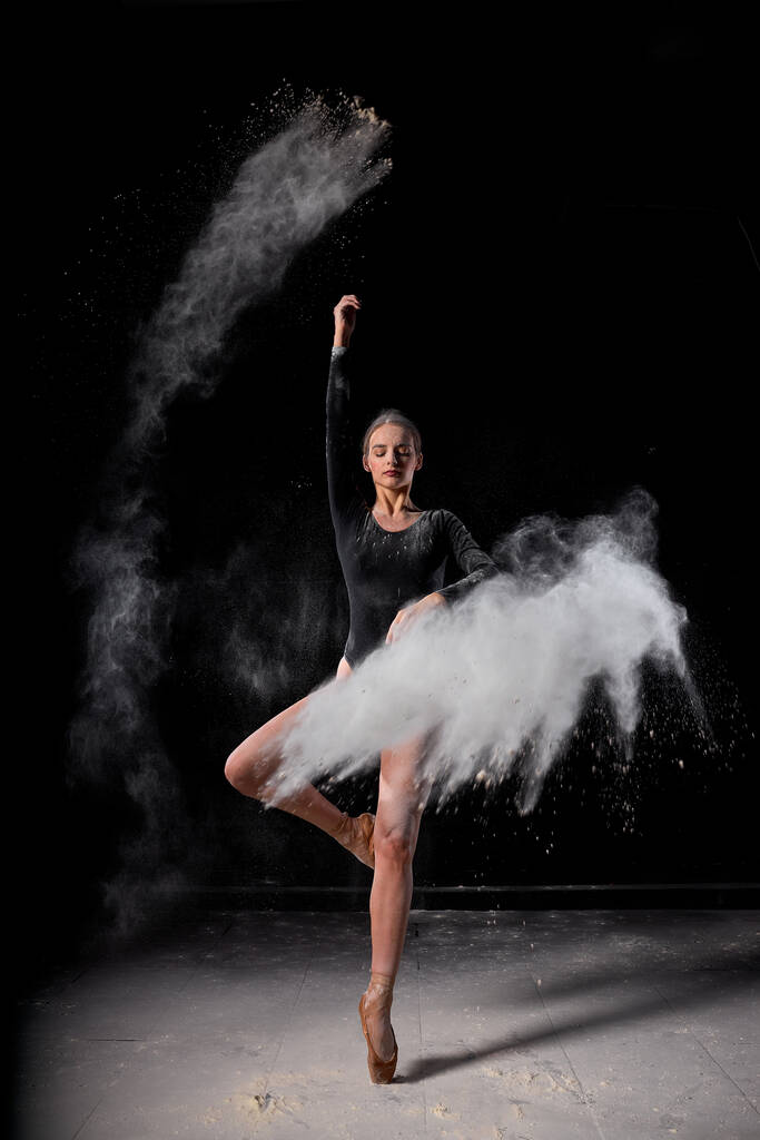Δραματικό πορτραίτο ισχυρής και ταλαντούχου χορεύτριας με έκρηξη λευκής σκόνης - Φωτογραφία, εικόνα