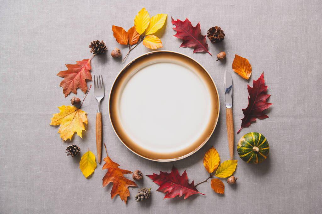 Ajuste de mesa de otoño de Acción de Gracias con cubiertos y arreglo de hojas de otoño coloridas y calabaza - Foto, imagen