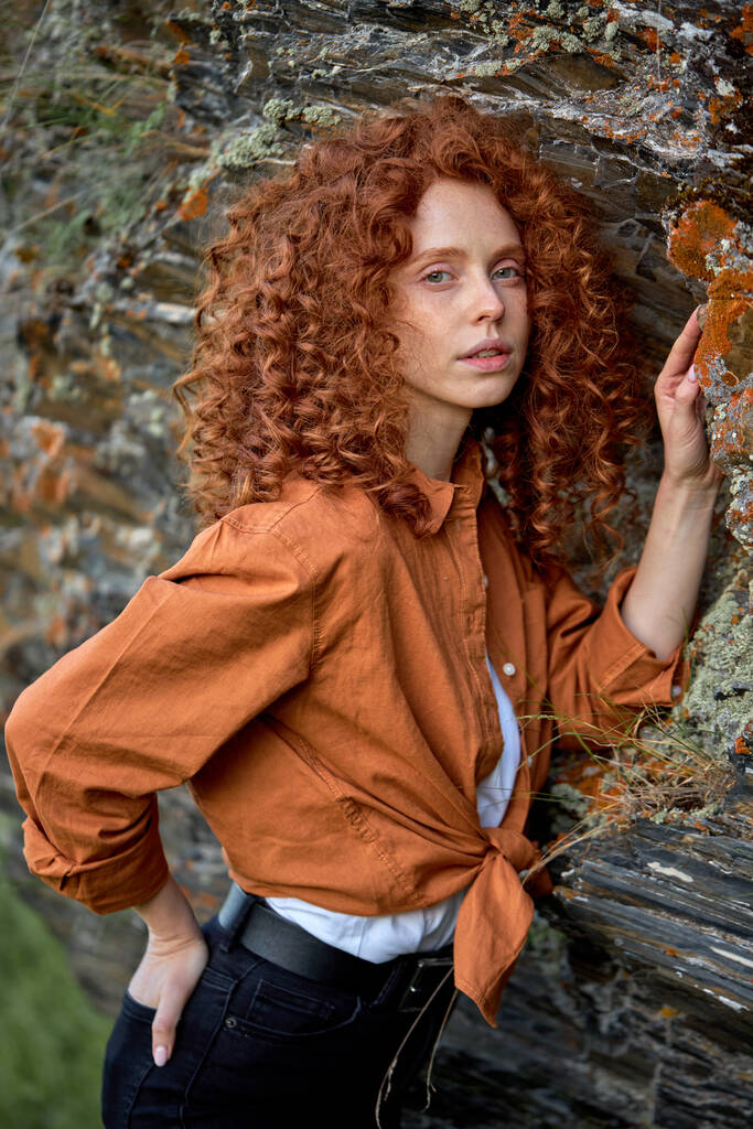 Femme de style romantique avec des cheveux roux naturels posant près des rochers. en bois sauvage - Photo, image