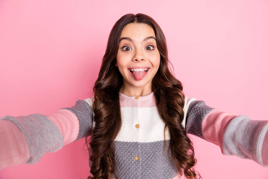 Photo of young attractive girl happy positive smile grimace tongue-out make selfie blogger isolated over pink color background - Photo, Image