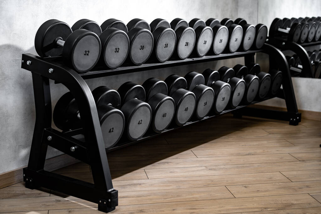 Reihen von Metallhanteln auf Rack für Bodybuilding im Fitnessstudio - Foto, Bild